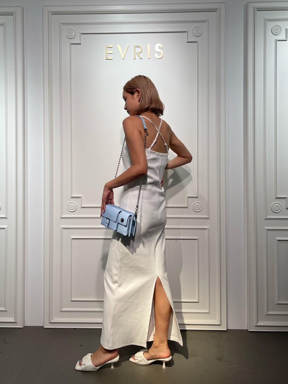 ホワイト系のサンダル、ホワイト系のワンピース、ブルー系のショルダーバッグを着用したレディースの夏コーディネートの3枚目の写真