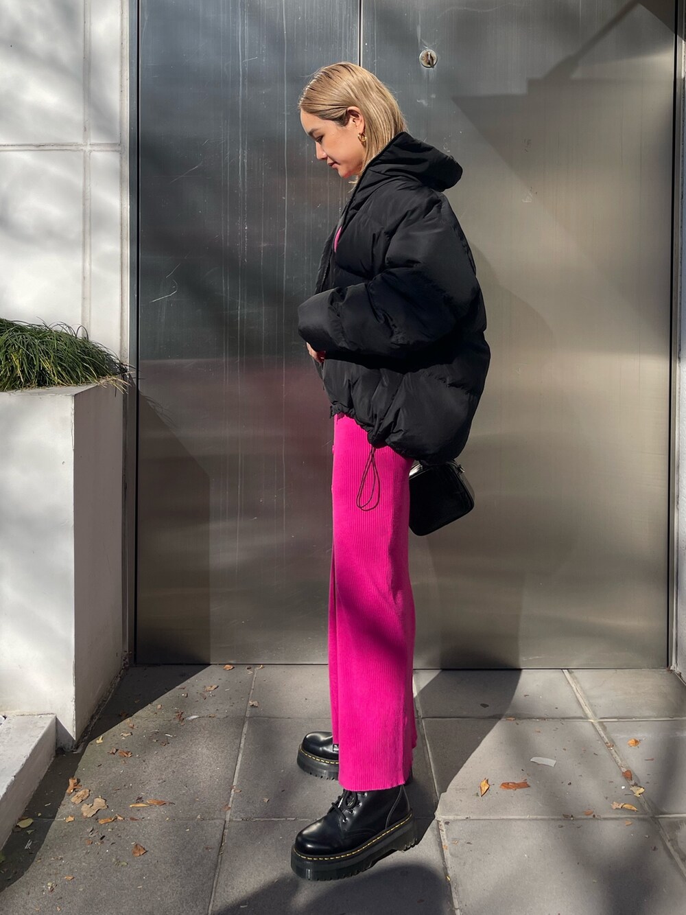 ブラック系のワンピース、ブラック系のショルダーバッグ、ブラック系のダウンジャケット/コートを着用したレディースの冬コーディネートの3枚目の写真