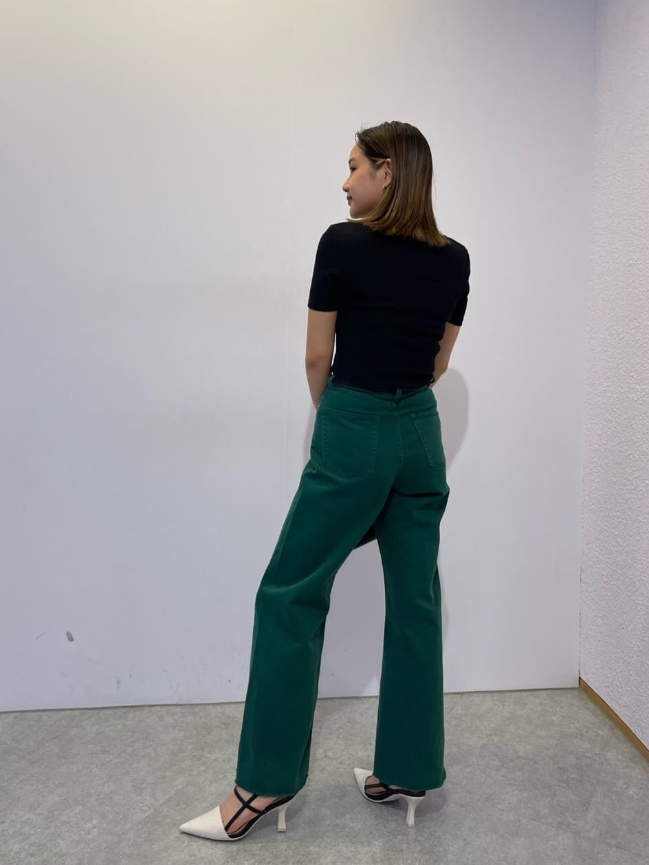 ブラック系のハンドバッグ、ホワイト系のサンダル、グリーン系のデニムパンツを着用したレディースの夏コーディネートの3枚目の写真