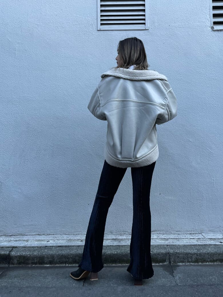 ホワイト系のブルゾン、ベージュ系のニット/セーター、ブラック系のその他パンツを着用したレディースの冬コーディネートの3枚目の写真