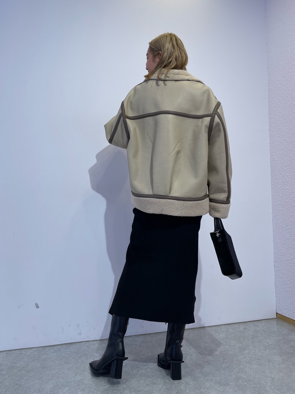 ブラック系のブーツ、ブラック系のショルダーバッグ、ブラック系のワンピースを着用したレディースの冬コーディネートの3枚目の写真