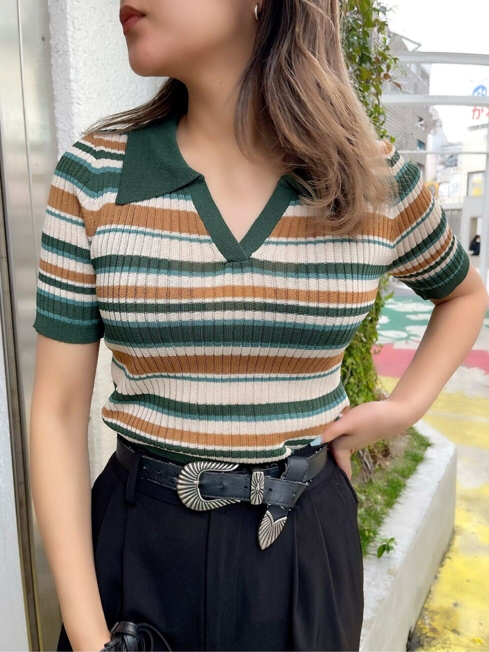 ブラック系のショルダーバッグ、グリーン系のニット/セーター、ブラック系のスラックスを着用したレディースの春コーディネートの4枚目の写真