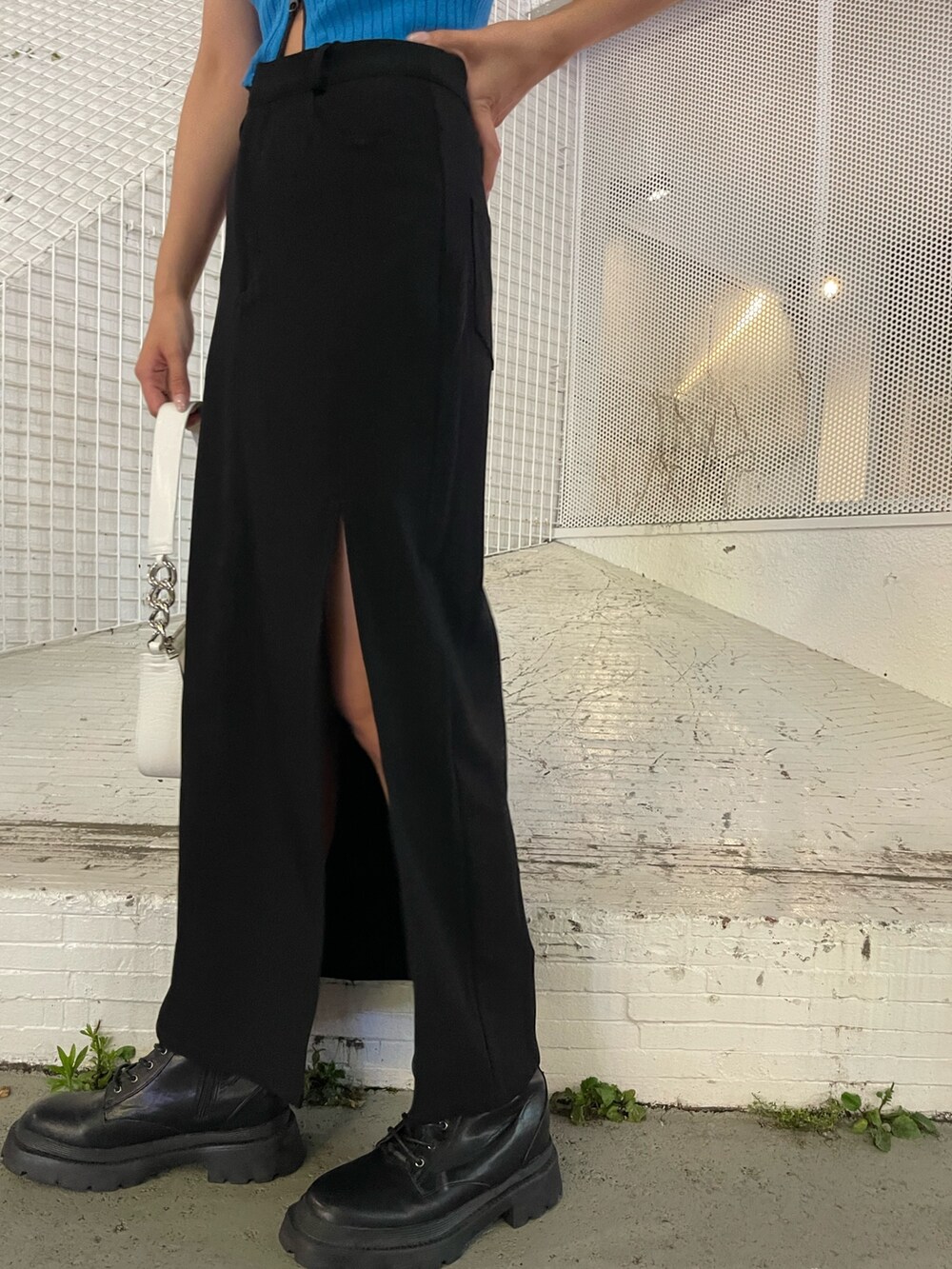 ブラック系のブーツ、ホワイト系のハンドバッグ、ブルー系のタンクトップを着用したレディースの夏コーディネートの7枚目の写真