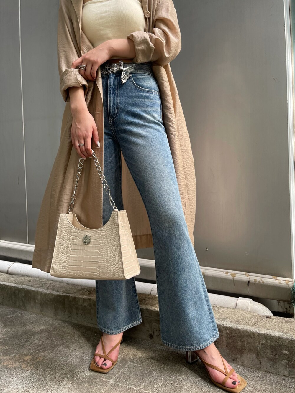 ベージュ系のその他アウター、ブルー系のデニムパンツ、ブラウン系のサンダルを着用したレディースの春コーディネートの2枚目の写真