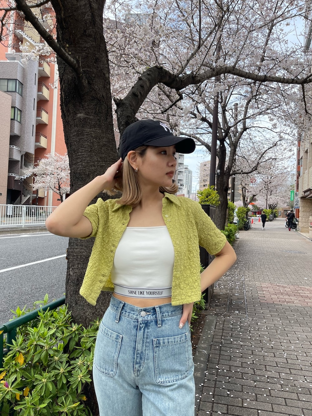 ブルー系のデニムパンツ、ホワイト系のキャミソール、グリーン系のシャツ/ブラウスを着用したレディースの春コーディネートの4枚目の写真