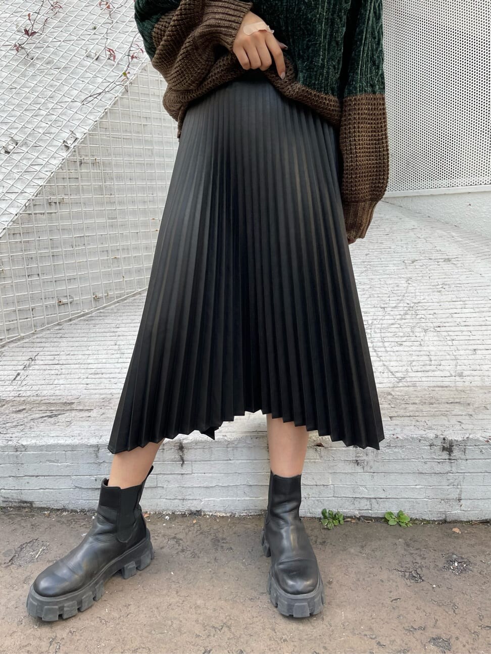 ブラック系のブーツ、ホワイト系のニット/セーター、ブラック系のスカートを着用したレディースの秋コーディネートの6枚目の写真