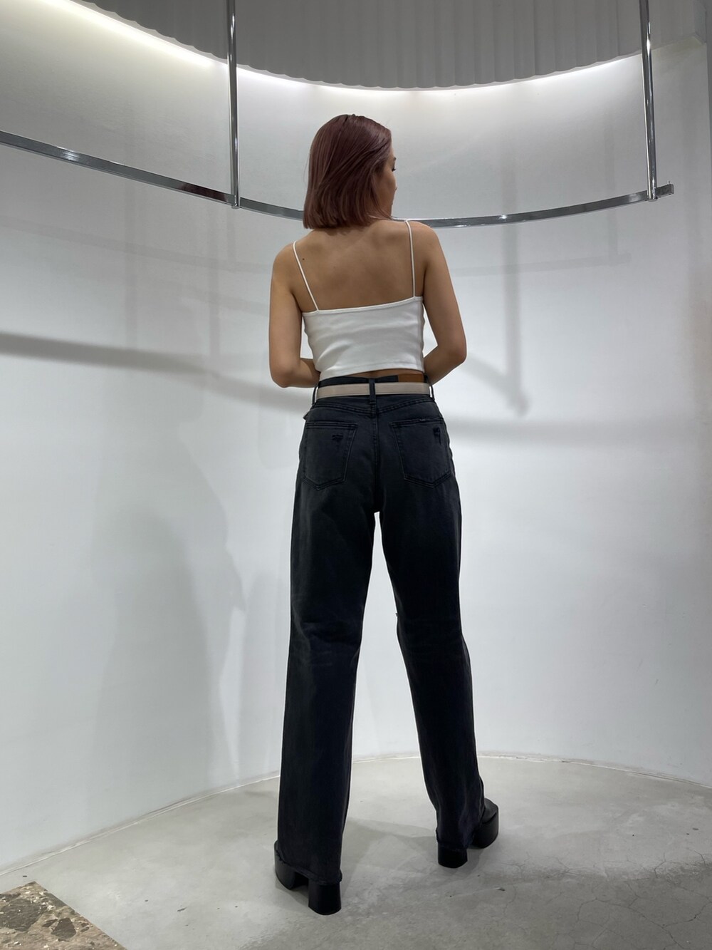 ホワイト系のキャミソール、ブラック系のデニムパンツ、ブラック系のサンダルを着用したレディースの夏コーディネートの4枚目の写真