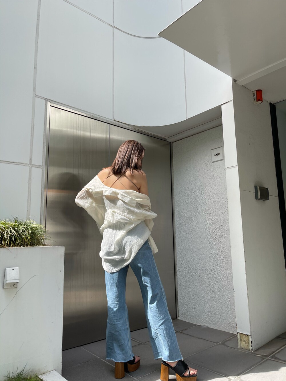 ホワイト系のシャツ/ブラウス、グリーン系のキャミソール、ブルー系のデニムパンツを着用したレディースの春コーディネートの3枚目の写真