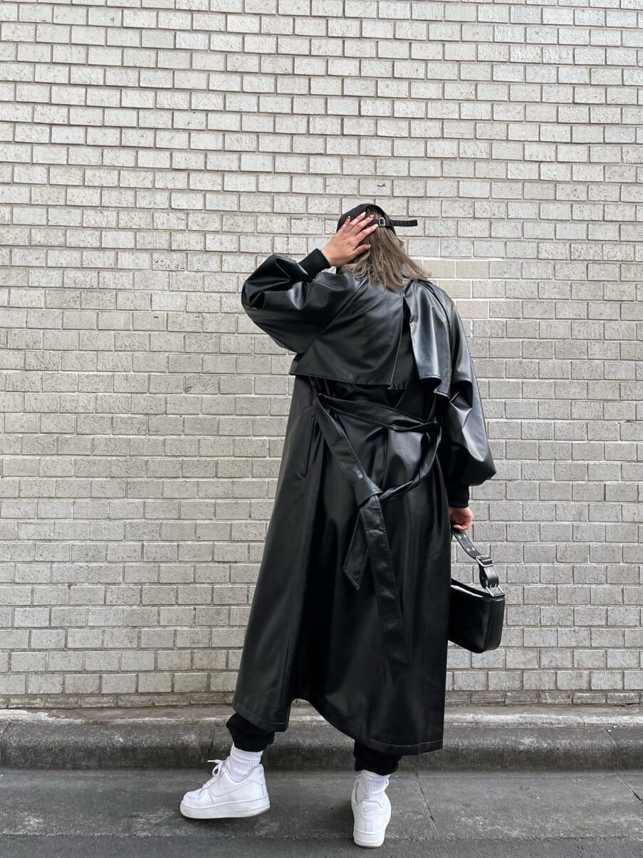 ブラック系のトレンチコート、グリーン系のシャツ/ブラウス、ブラック系のショルダーバッグを着用したレディースの冬コーディネートの2枚目の写真