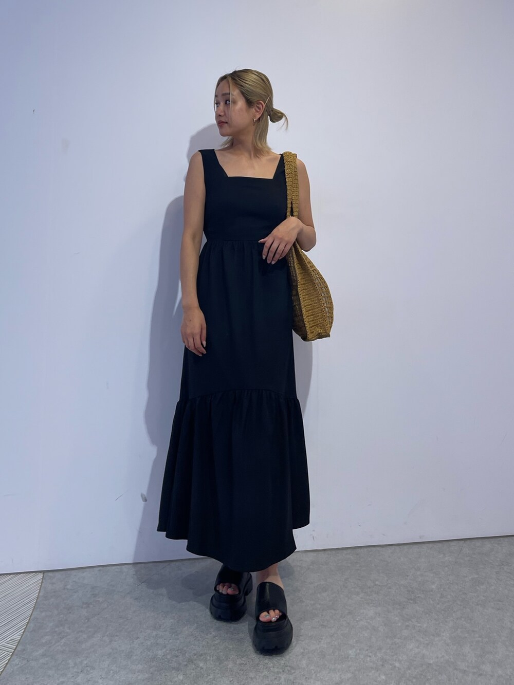 ベージュ系のトートバッグ、ブラック系のワンピース、ブラック系のサンダルを着用したレディースの夏コーディネートの2枚目の写真