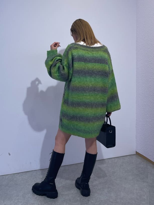 ブラック系のブーツ、ブラック系のショルダーバッグ、グリーン系のカーディガン/ボレロを着用したレディースの秋コーディネートの3枚目の写真