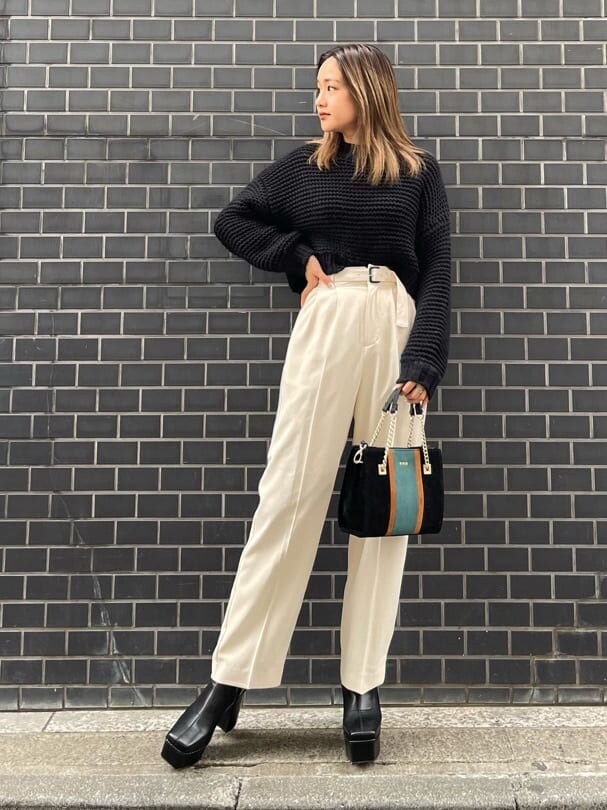 ブラック系のブーツ、ブラック系のニット/セーター、ブラック系のショルダーバッグを着用したレディースの冬コーディネートの2枚目の写真