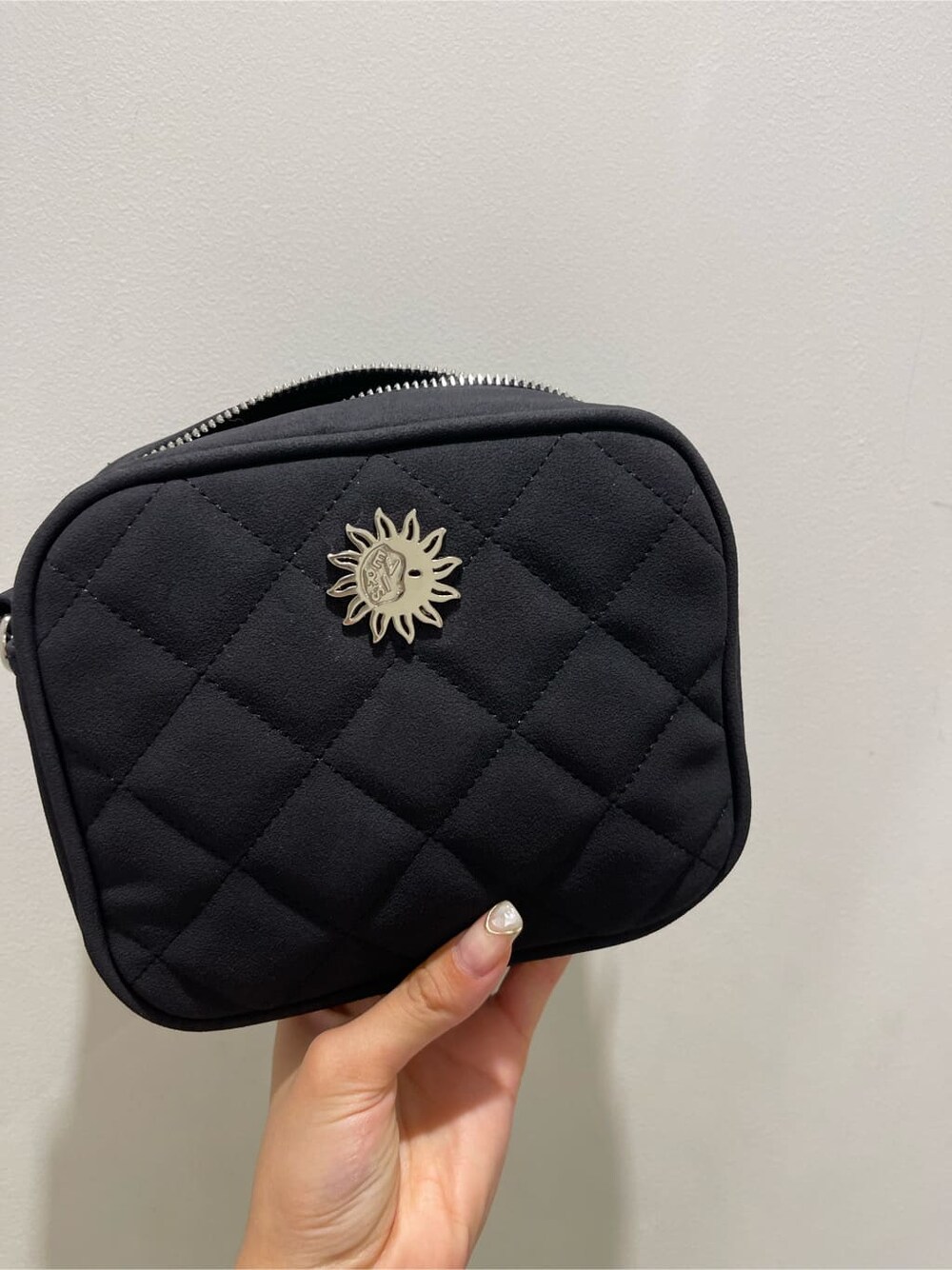 ブラック系のショルダーバッグ、ブラック系のスカート、ホワイト系のTシャツ/カットソーを着用したレディースの夏コーディネートの7枚目の写真