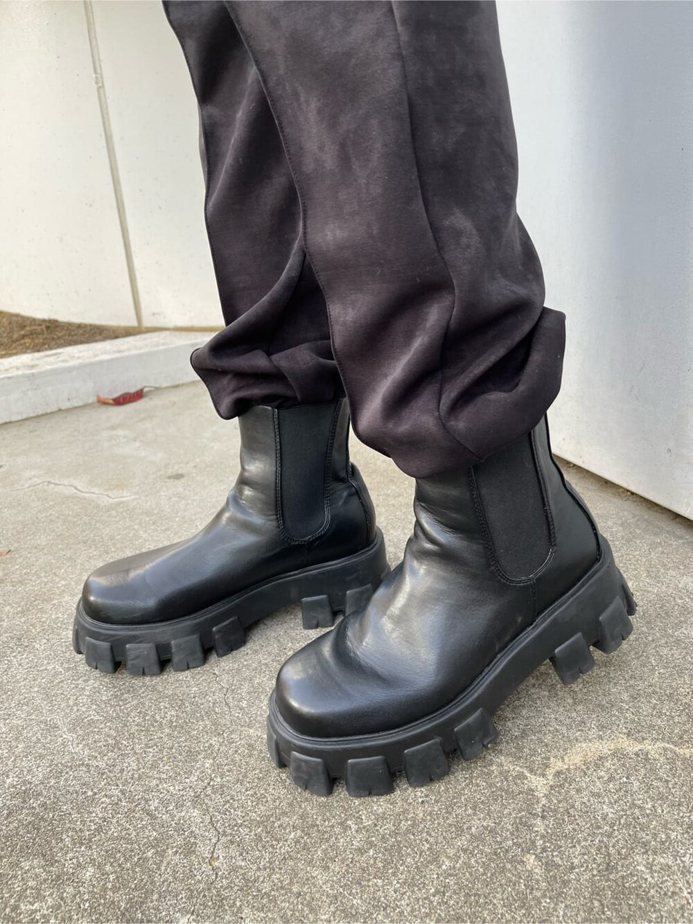 ブラック系のブーツ、ホワイト系のスウェット、ブラック系のスウェットパンツを着用したレディースの秋コーディネートの6枚目の写真