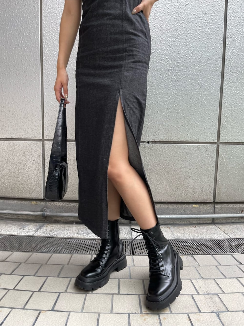 ブラック系のハンドバッグ、ブラック系のワンピース、ブラック系のブーツを着用したレディースの夏コーディネートの7枚目の写真