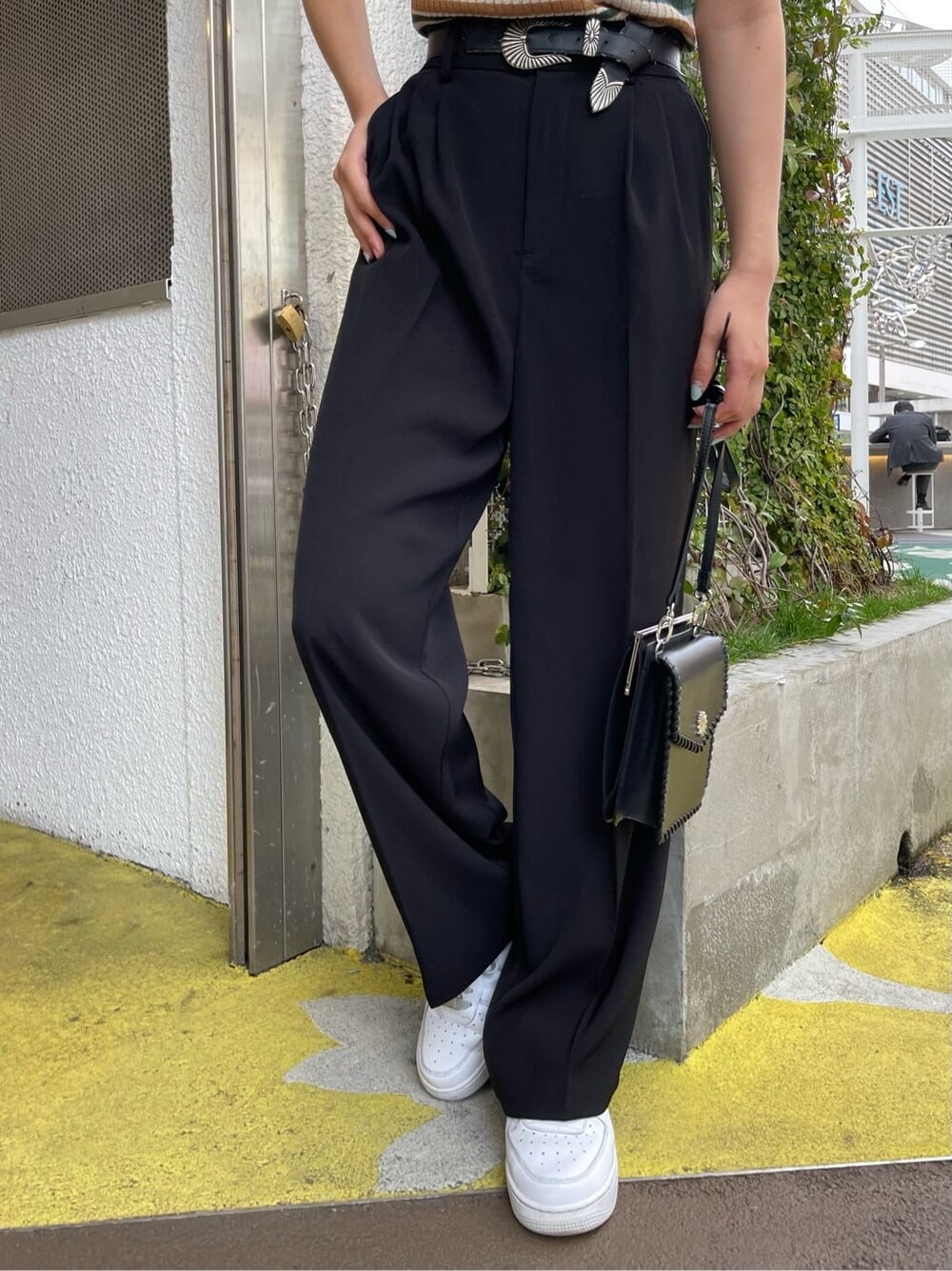 ブラック系のショルダーバッグ、グリーン系のニット/セーター、ブラック系のスラックスを着用したレディースの春コーディネートの6枚目の写真