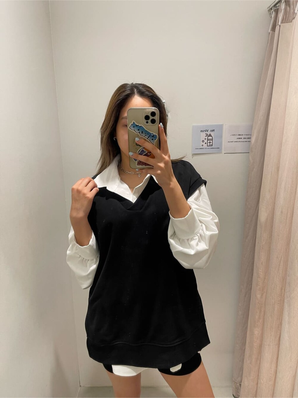 ホワイト系のシャツ/ブラウス、ブラック系のブーツ、ブラック系のベストを着用したレディースの春コーディネートの4枚目の写真