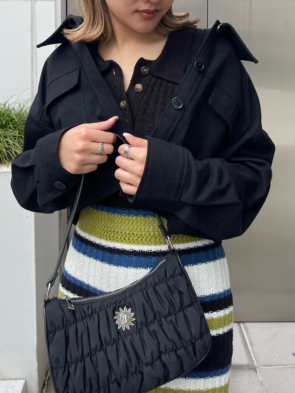 ブラック系のワンピース、ブラック系のハンドバッグを着用したレディースの春コーディネートの5枚目の写真