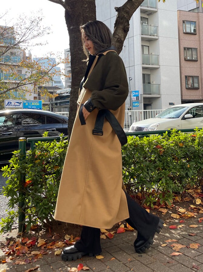 ブラック系のその他パンツ、その他のブーツ、ベージュ系のトレンチコートを着用したレディースの秋コーディネートの4枚目の写真