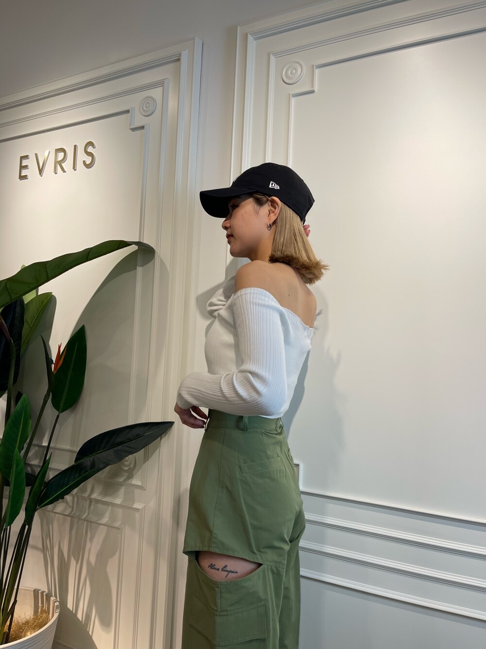 グリーン系のニット/セーター、ブラック系のブーツ、ベージュ系のカーゴパンツを着用したレディースの春コーディネートの6枚目の写真