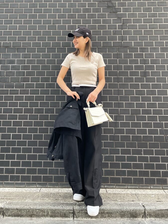 ブラック系のブルゾン、ホワイト系のショルダーバッグ、ベージュ系のTシャツ/カットソーを着用したレディースの春コーディネートの3枚目の写真