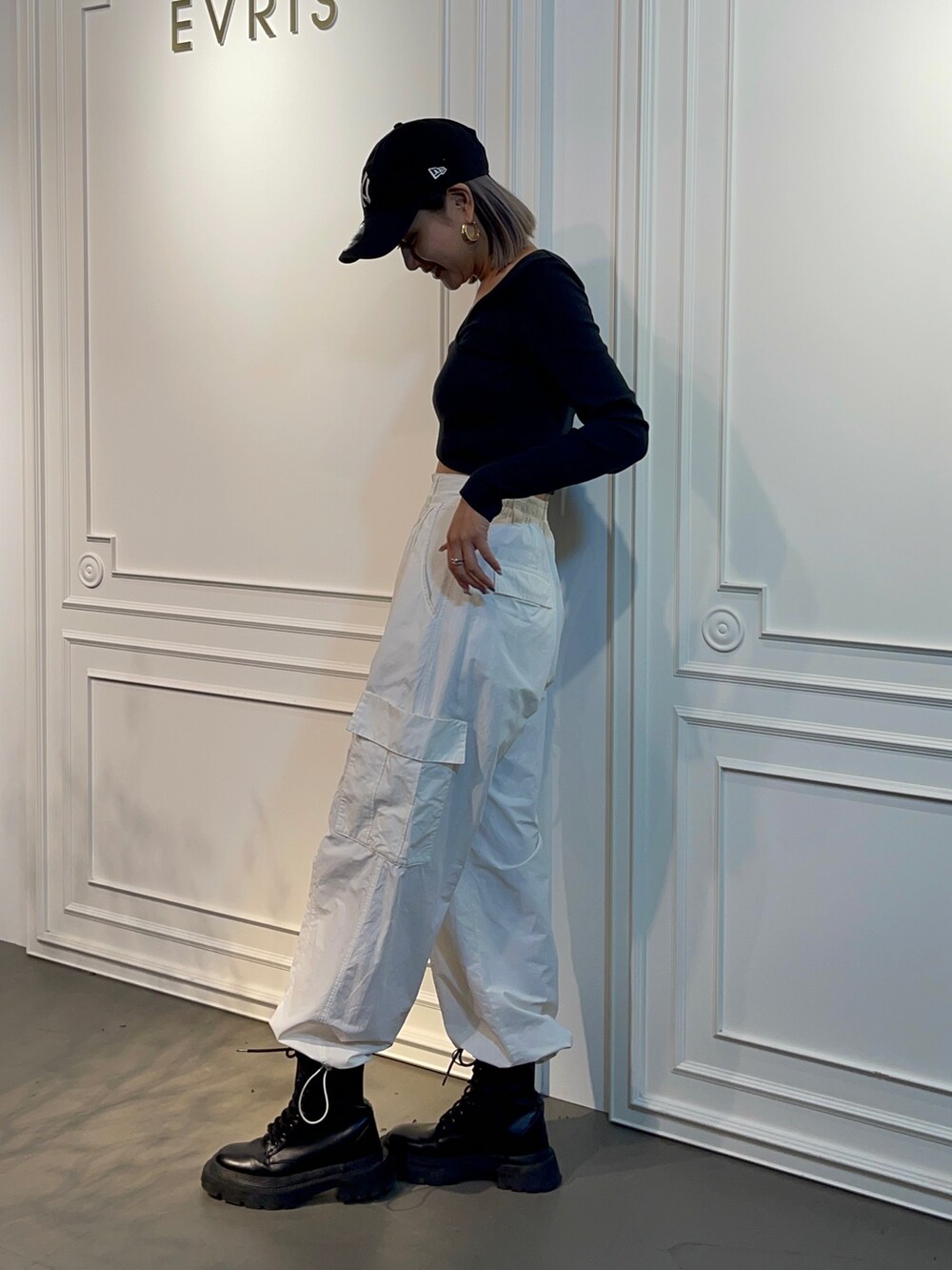 ホワイト系のカーゴパンツ、ブラック系のブーツ、ブラック系のTシャツ/カットソーを着用したレディースの秋コーディネートの2枚目の写真