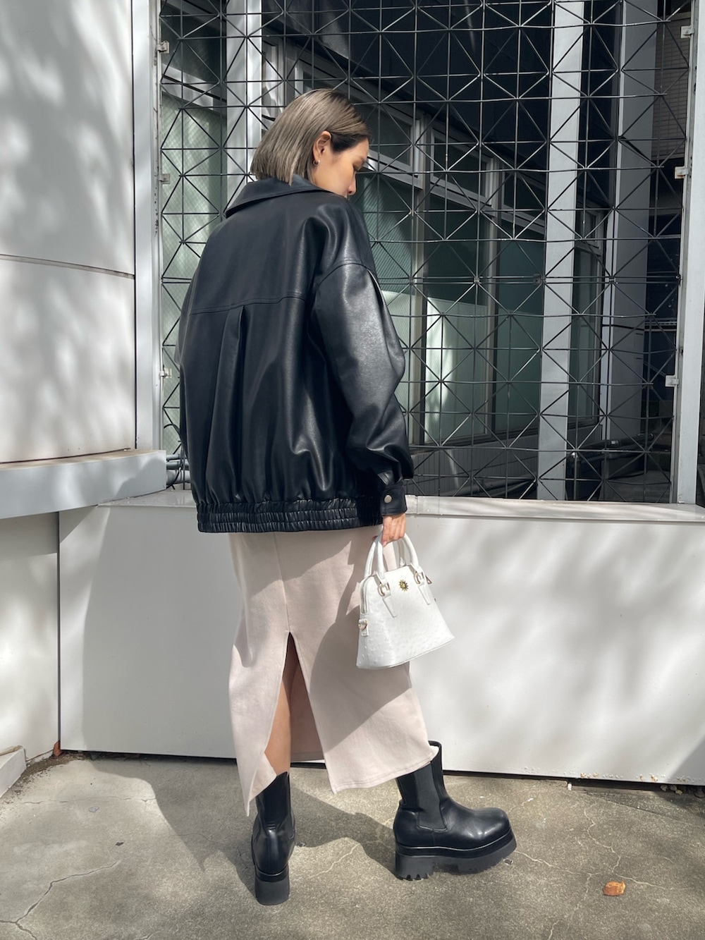 ホワイト系のワンピース、ホワイト系のショルダーバッグ、ブラック系のブルゾンを着用したレディースの秋コーディネートの3枚目の写真