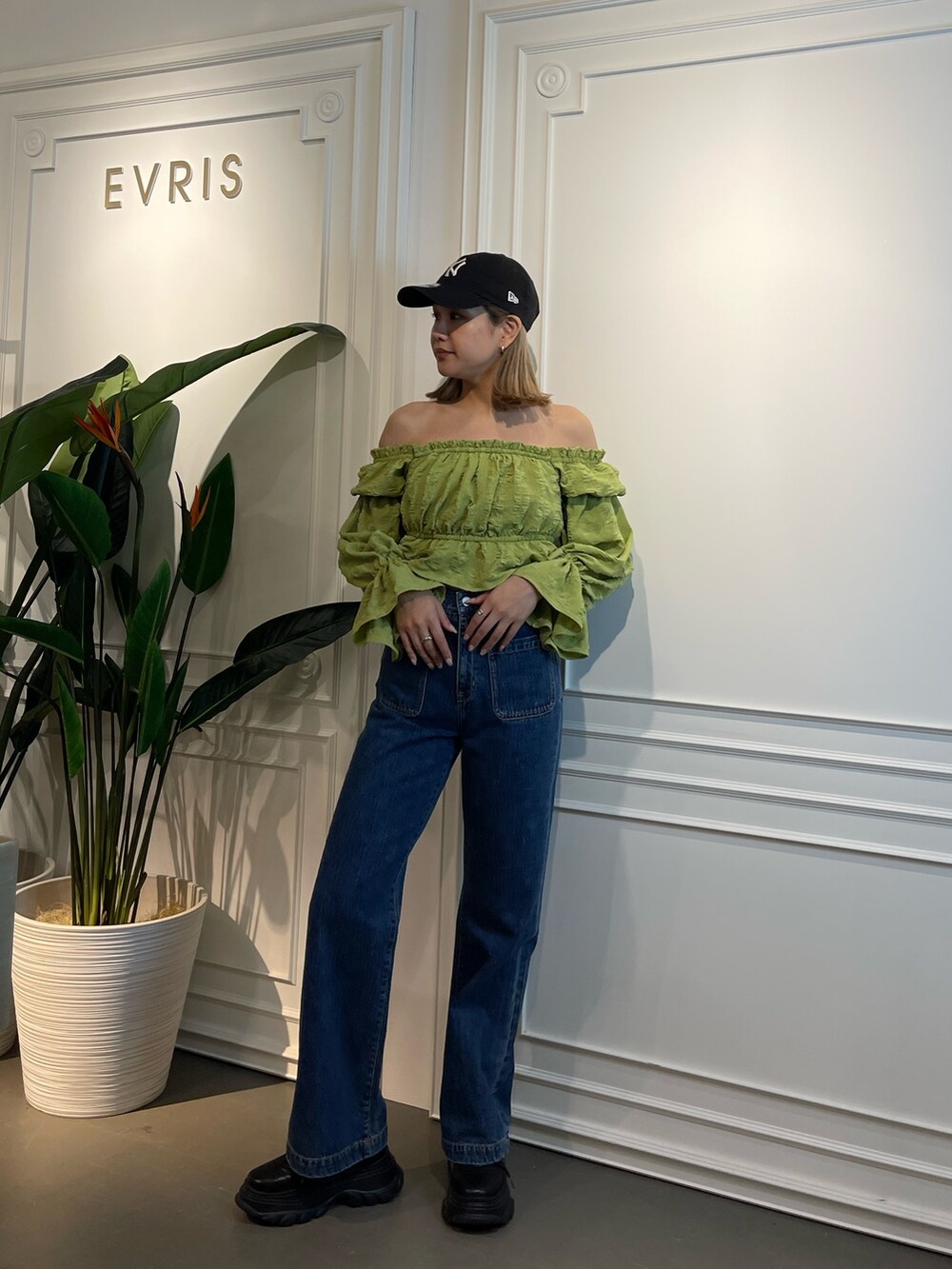 ブルー系のデニムパンツ、ブラック系のスニーカー、グリーン系のシャツ/ブラウスを着用したレディースの春コーディネートの2枚目の写真