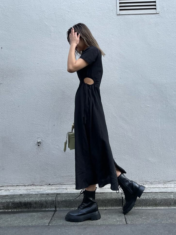 ブラック系のブーツ、グリーン系のショルダーバッグ、ブラック系のワンピースを着用したレディースの春コーディネートの4枚目の写真