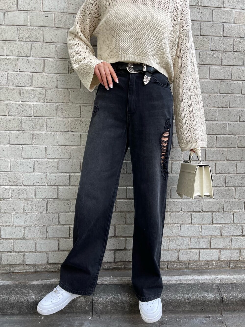 ホワイト系のキャミソール、ブラック系のデニムパンツ、ホワイト系のニット/セーターを着用したレディースの春コーディネートの7枚目の写真