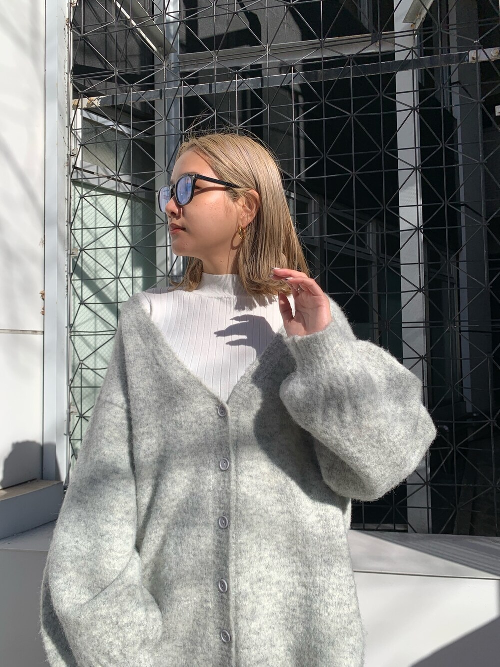 グレー系のカーディガン/ボレロ、ブラック系のブーツ、ホワイト系のTシャツ/カットソーを着用したレディースの冬コーディネートの5枚目の写真