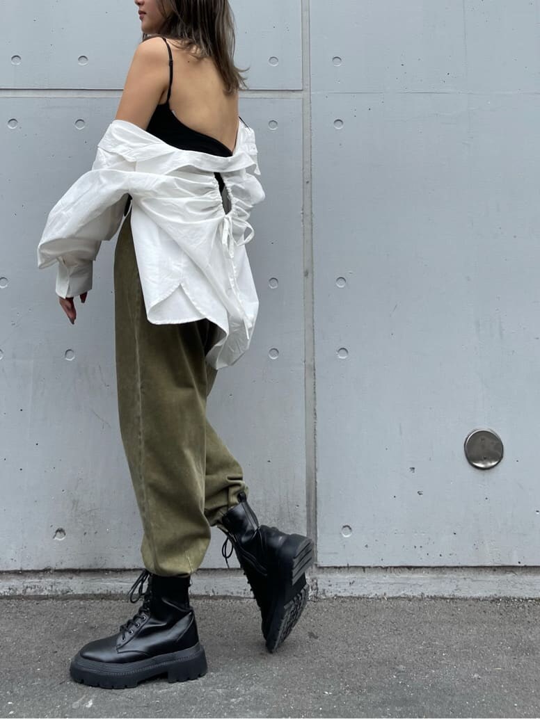 ブラック系のブーツ、ホワイト系のシャツ/ブラウス、ベージュ系のデニムパンツを着用したレディースの夏コーディネートの4枚目の写真