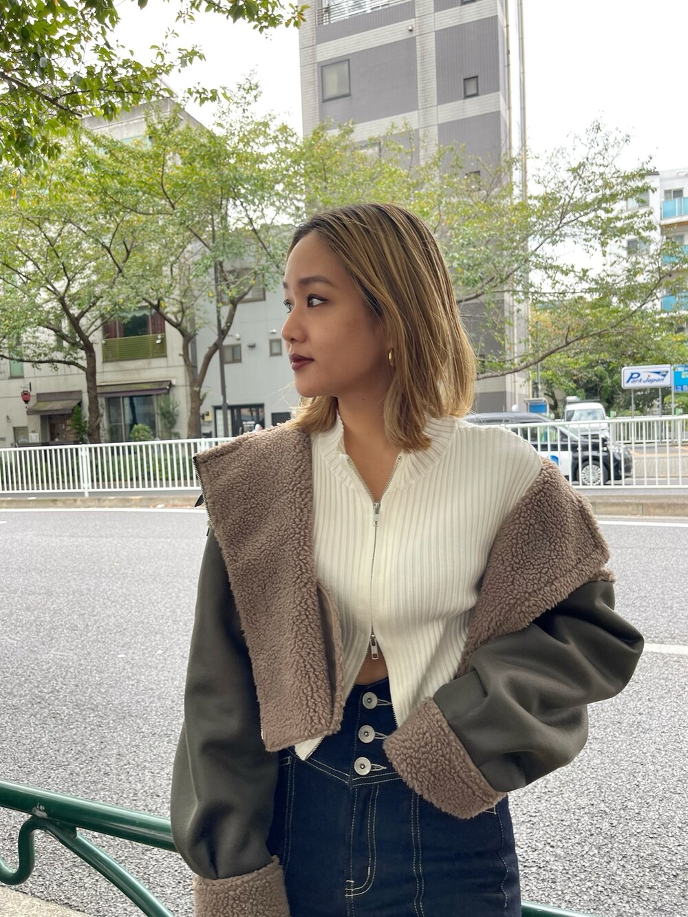 ブラック系のブーツ、ホワイト系のニット/セーター、グリーン系のブルゾンを着用したレディースの秋コーディネートの4枚目の写真