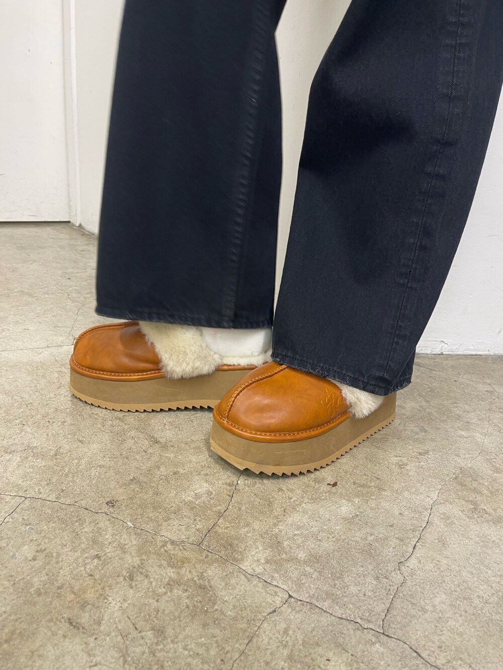 イエロー系のニット/セーター、ブラック系のデニムパンツ、ベージュ系のスリッポンを着用したレディースの秋コーディネートの8枚目の写真