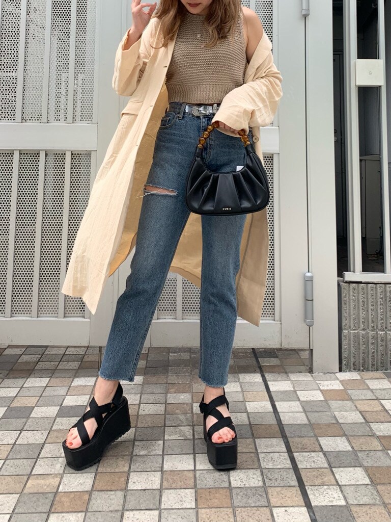 ブルー系のデニムパンツ、ブラック系のサンダル、ベージュ系のチェスターコートを着用したレディースの春コーディネートの5枚目の写真