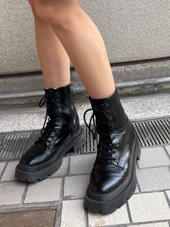 ブラック系のブーツ、ブラック系のワンピース、グリーン系のショルダーバッグを着用したレディースの秋コーディネートの6枚目の写真