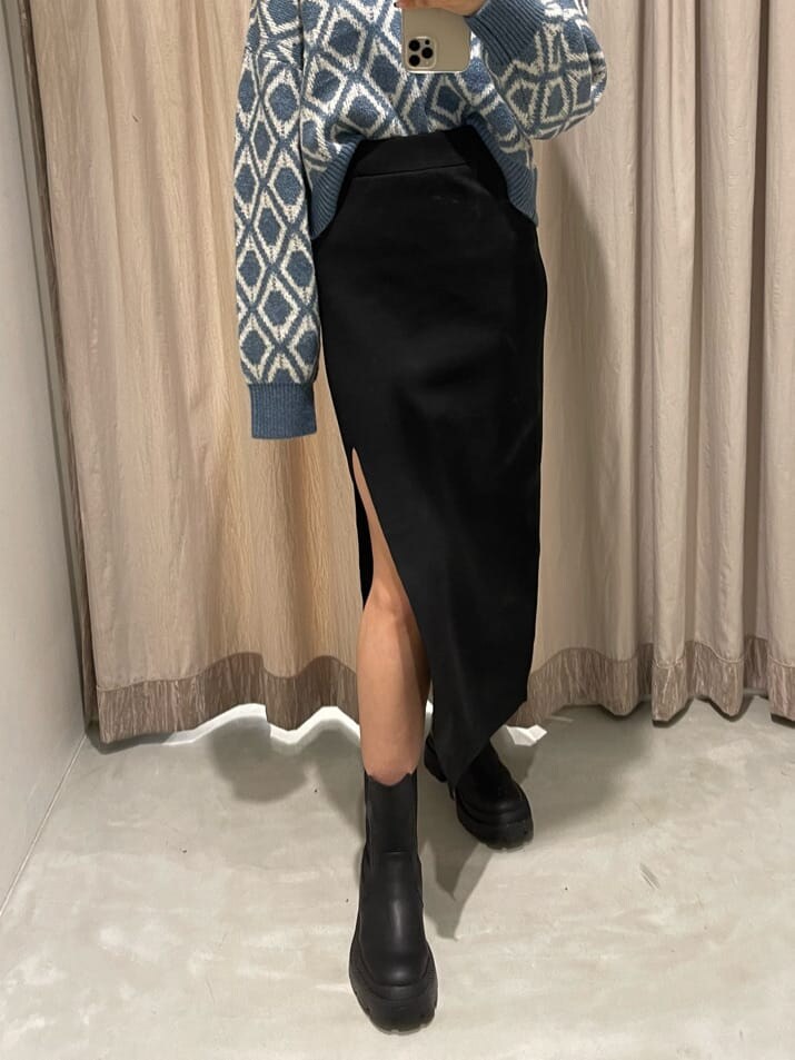ブルー系のニット/セーター、ブラック系のスカート、ブラック系のブーツを着用したレディースの秋コーディネートの5枚目の写真