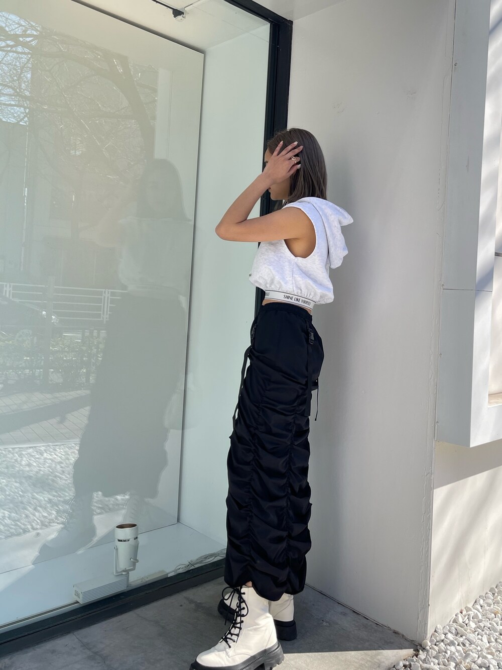 ホワイト系のブーツ、グレー系のスウェット、ホワイト系のショルダーバッグを着用したレディースの春コーディネートの3枚目の写真