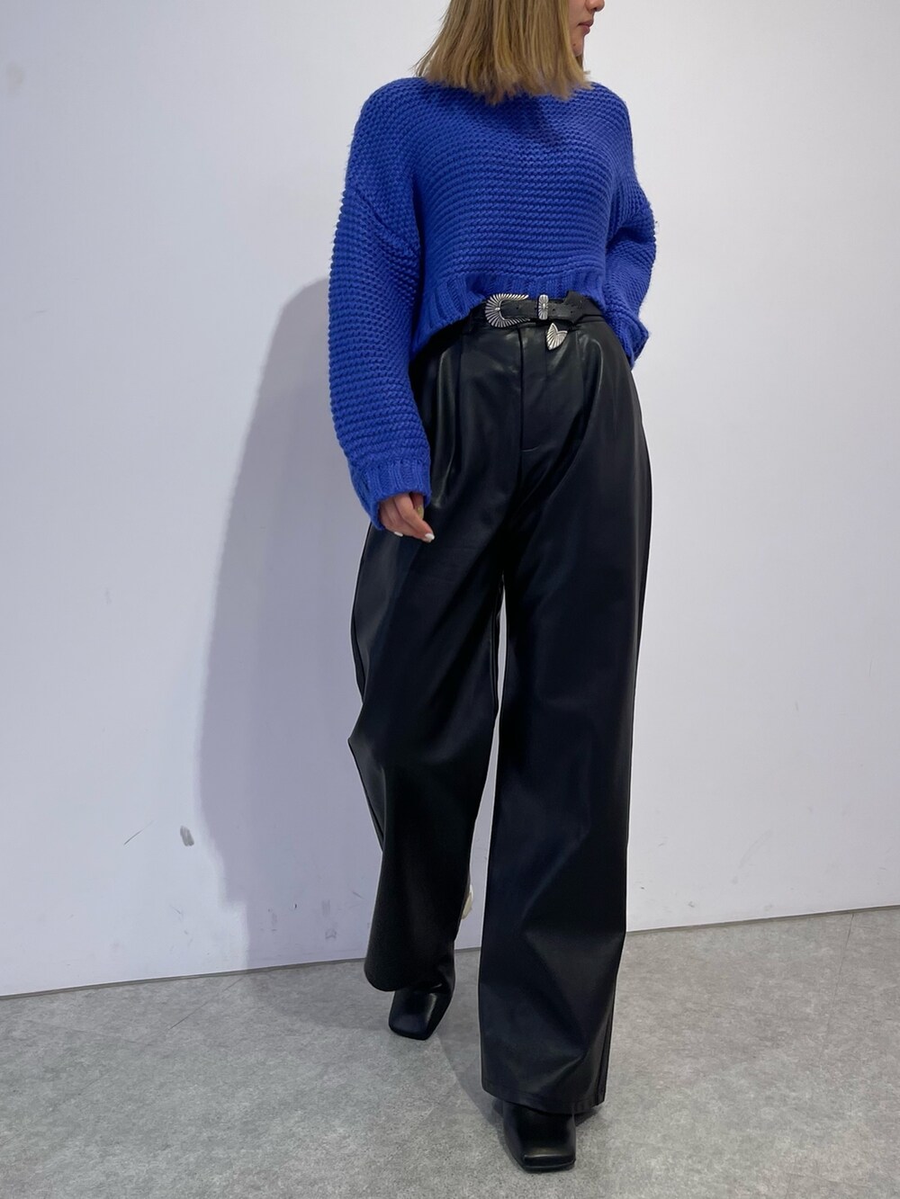 ブラック系のブーツ、ブルー系のニット/セーター、ブラック系のその他パンツを着用したレディースの冬コーディネートの3枚目の写真