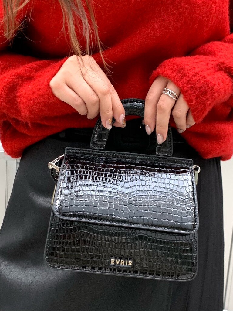 レッド系のニット/セーター、ブラック系のスカートを着用したレディースの秋コーディネートの6枚目の写真