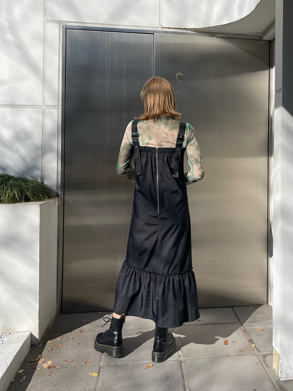 ブラック系のワンピース、ブラック系のショルダーバッグ、ブラック系のブーツを着用したレディースの冬コーディネートの3枚目の写真