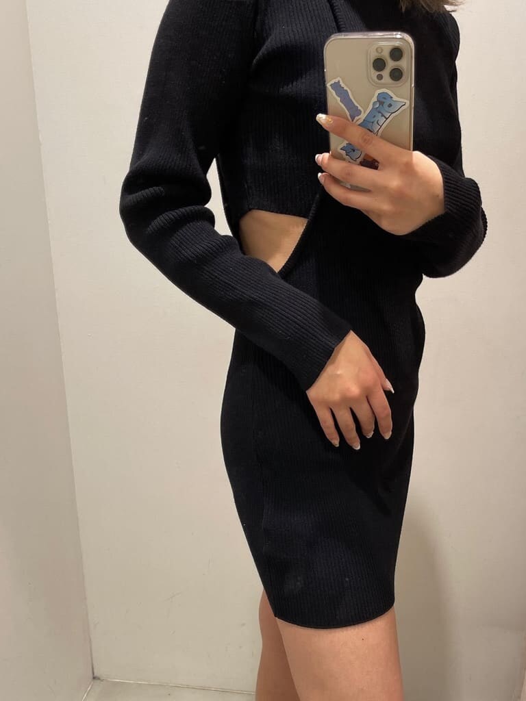 ブラック系のワンピース、ブラック系のブーツ、ホワイト系のブルゾンを着用したレディースの冬コーディネートの6枚目の写真