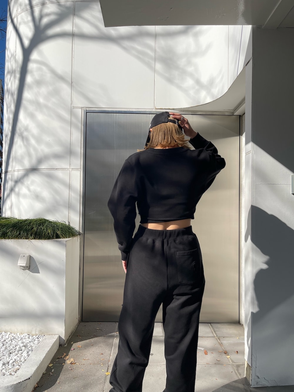 ブラック系のスウェットパンツ、ブラック系のブーツ、ブラック系のTシャツ/カットソーを着用したレディースの冬コーディネートの6枚目の写真