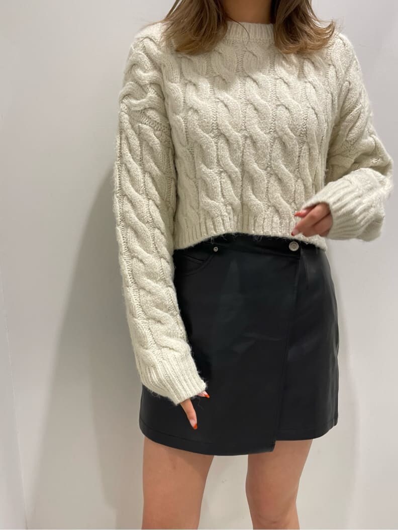 ブラック系のブーツ、ブラック系のスカート、ホワイト系のニット/セーターを着用したレディースの秋コーディネートの3枚目の写真