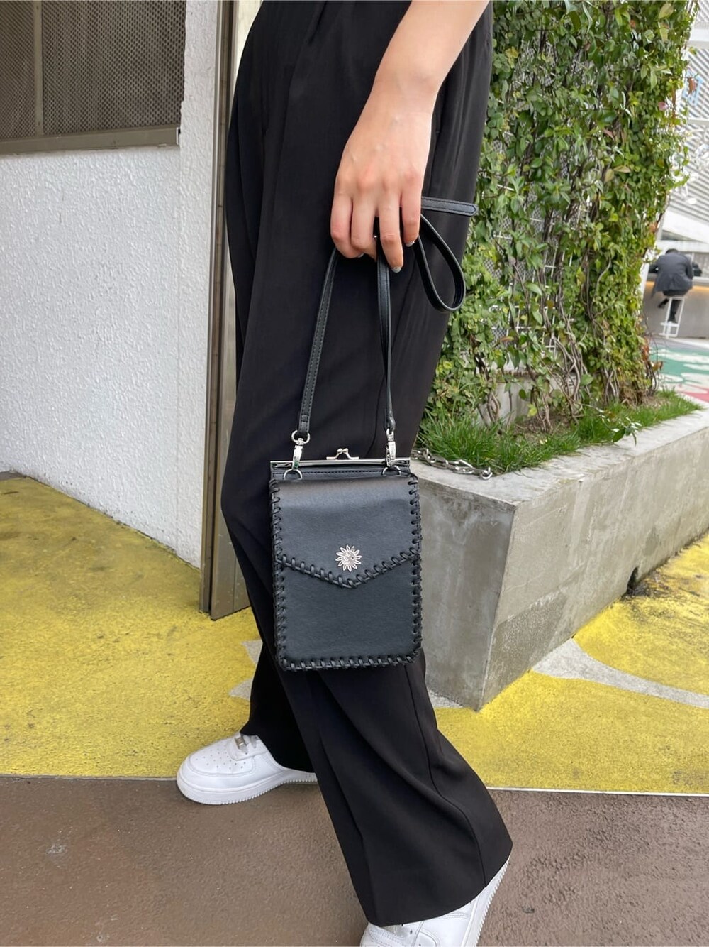 ブラック系のショルダーバッグ、グリーン系のニット/セーター、ブラック系のスラックスを着用したレディースの春コーディネートの7枚目の写真