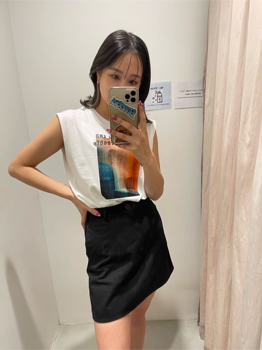 ブラック系のスカート、ホワイト系のTシャツ/カットソー、ブラック系のブーツを着用したレディースの春コーディネートの6枚目の写真