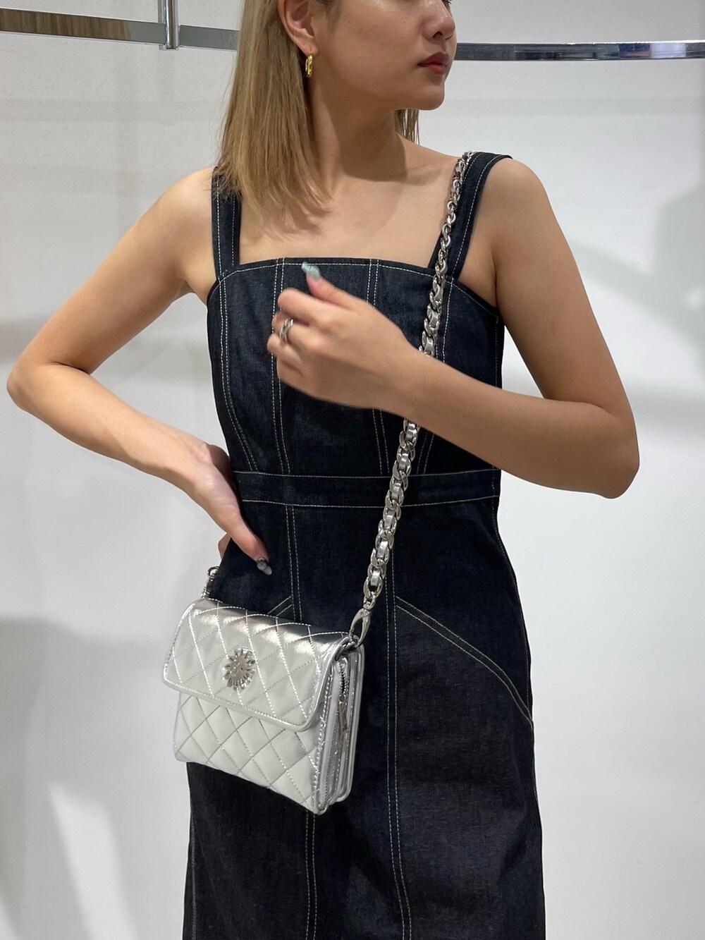 シルバー系のショルダーバッグ、ブラック系のサンダル、ブラック系のワンピースを着用したレディースの春コーディネートの6枚目の写真