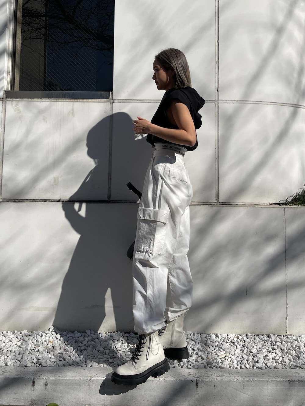 ホワイト系のカーゴパンツ、ブラック系のスウェット、ホワイト系のブーツを着用したレディースの春コーディネートの2枚目の写真