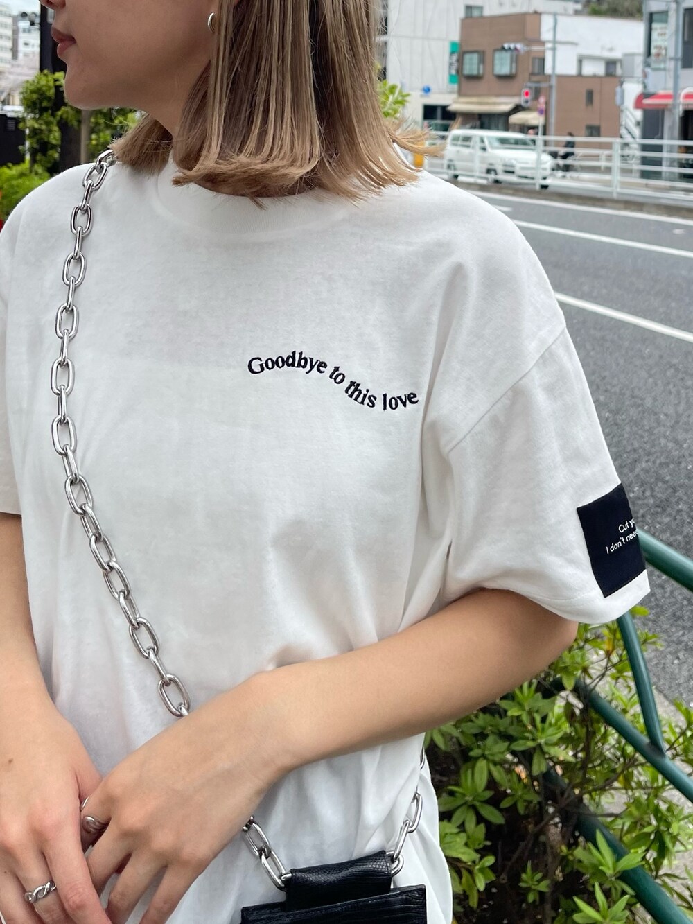 ブラック系のショルダーバッグ、ホワイト系のTシャツ/カットソー、ブルー系のスカートを着用したレディースの春コーディネートの7枚目の写真