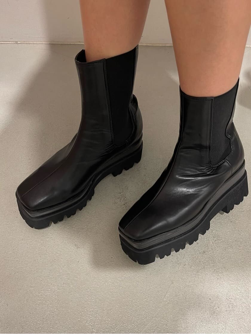 ブラック系のブーツ、ブラック系のワンピース、ブラック系のキャップを着用したレディースの夏コーディネートの9枚目の写真